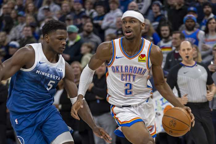 Jan 20, 2024; Minneapolis, Minnesota, USA; Oklahoma City Thunder guard Shai Gilgeous-Alexander (2) dribbles the ball around Minnesota Timberwolves guard Anthony Edwards (5) in the first half at Target Center.